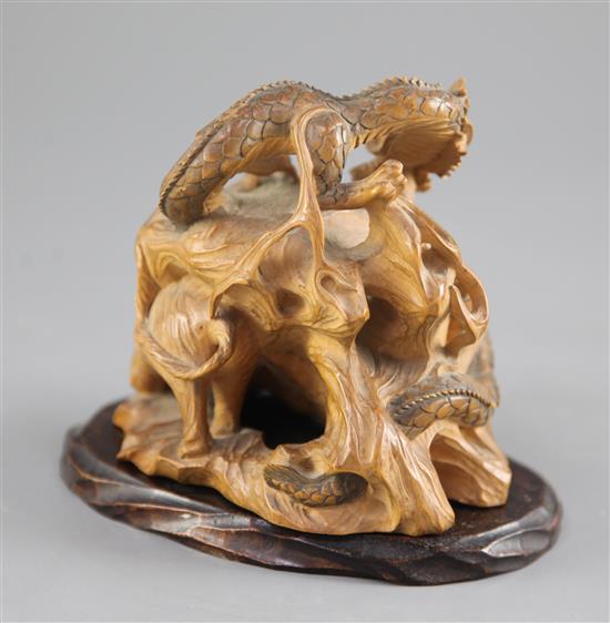 A Japanese boxwood okimono modelled as a dragon and a tiger, early 20th century, height 11cm, associated wood stand